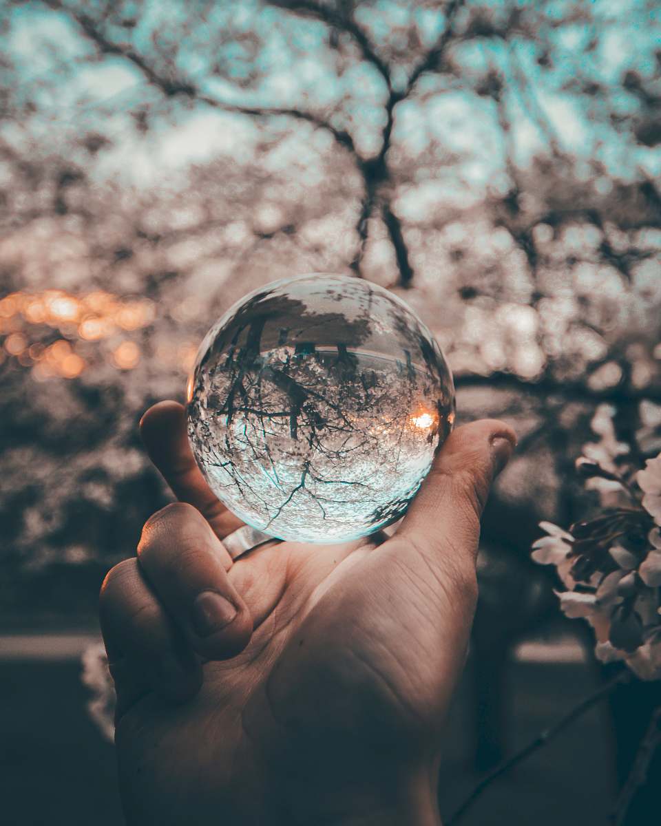 reflection person holding round glass ball glass